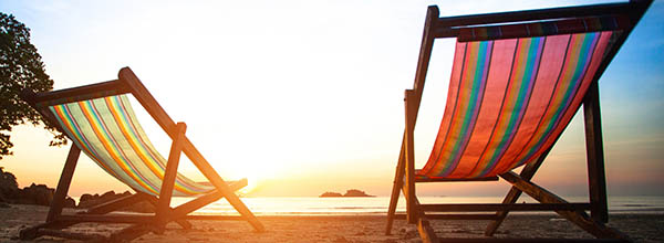 Zwei Strandstühle am Meer mit Sonnenuntergang